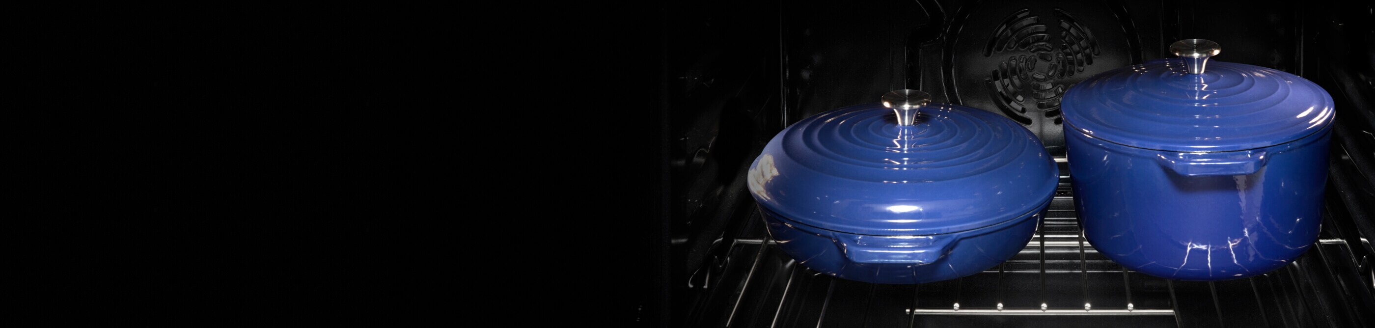 Two covered blue ceramic pots on an oven rack