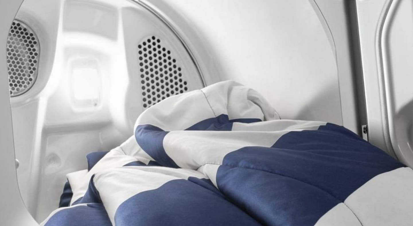 An open Maytag® dryer with a blanket coming out. An open Maytag® dryer with a blanket coming out.