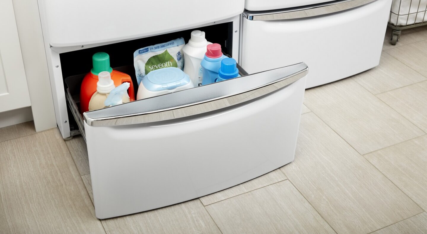 Close-up of open white laundry pedestal drawer with supplies inside