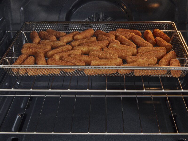 Mozzarella sticks in air fryer basket Mozzarella sticks in air fryer basket