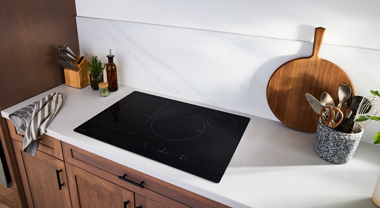Induction cooktop on white countertops with wood cabinets