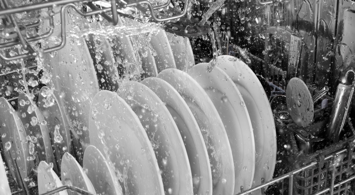 A closeup of the lower rack of the interior of a Maytag® dishwasher during a rinse cycle. A closeup of the lower rack of the interior of a Maytag® dishwasher during a rinse cycle.