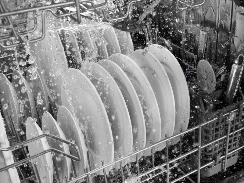 A closeup of the lower rack of the interior of a Maytag® dishwasher during a rinse cycle. A closeup of the lower rack of the interior of a Maytag® dishwasher during a rinse cycle.