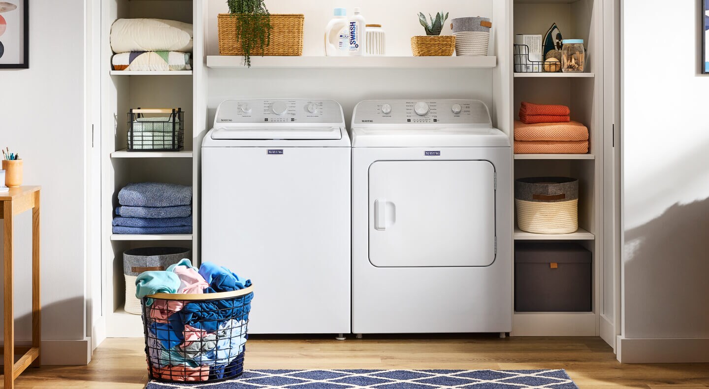 White Maytag® top load laundry pair installed between built-in shelving