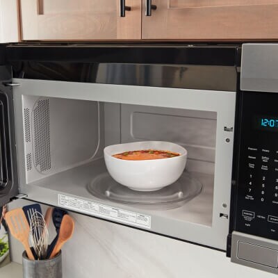 Bowl of soup inside an open microwave
