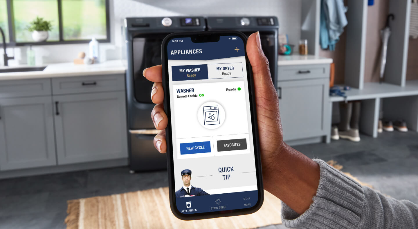 Close-up of person holding phone with the Maytag™ app open on screen