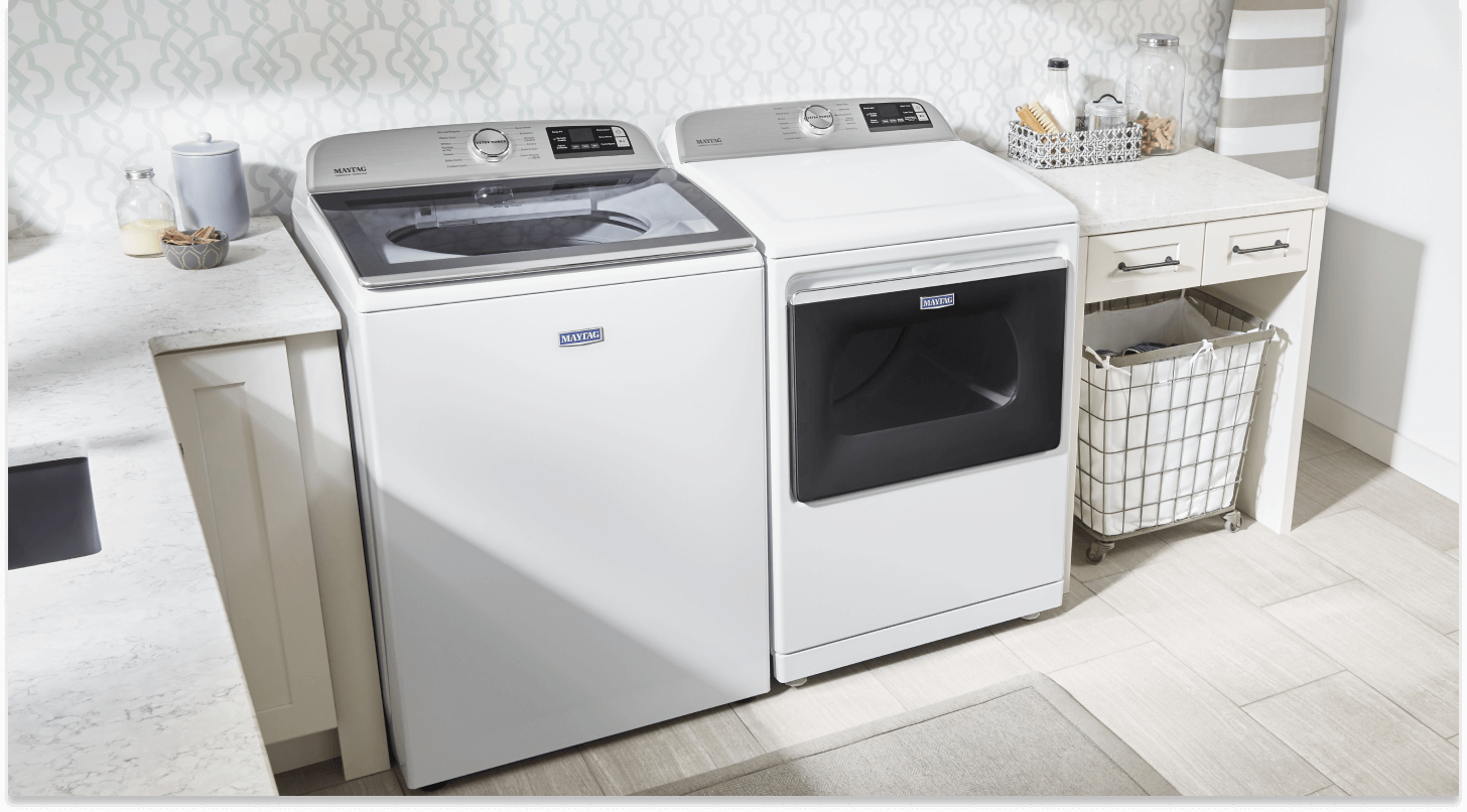 White top-load Maytag® laundry pair between laundry room cabinetry