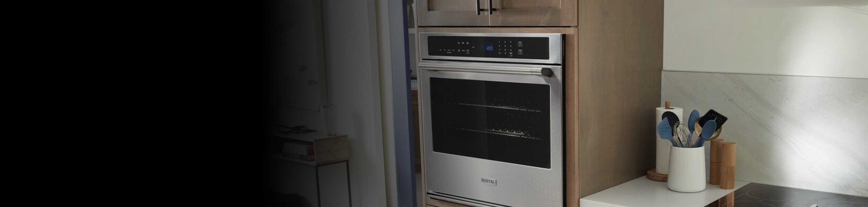 A Maytag® wall oven and a view of kitchen accessories on a countertop