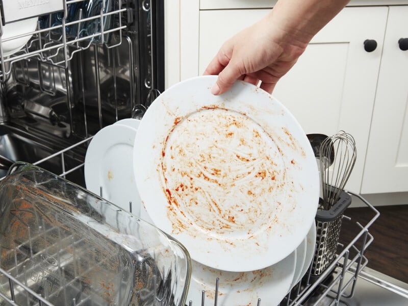 A person placing a dirty dish in a Maytag® dishwasher A person placing a dirty dish in a Maytag® dishwasher