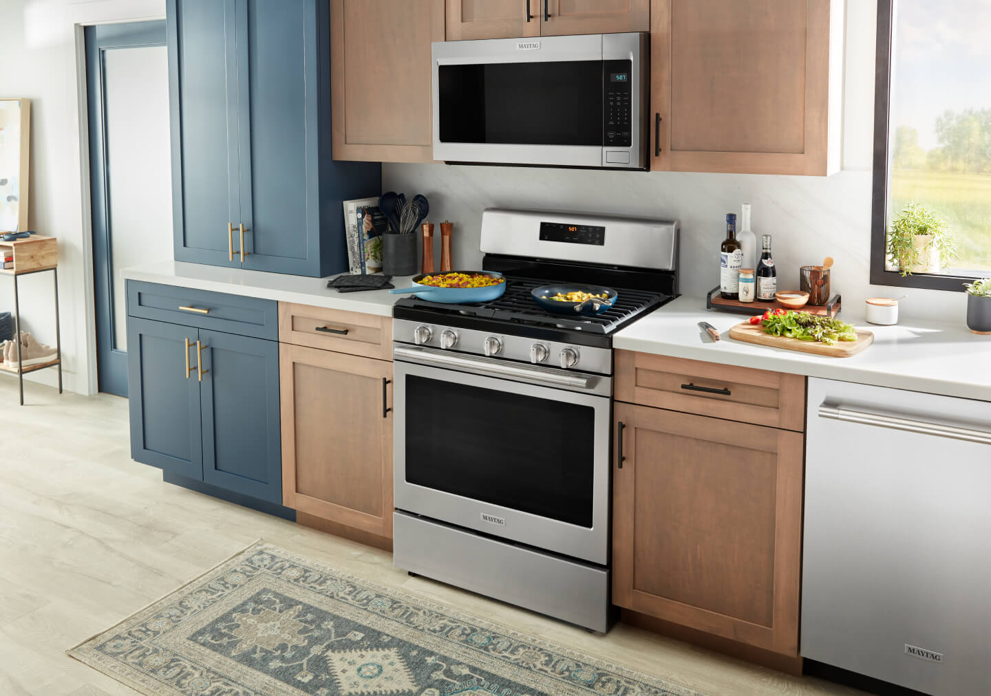 Maytag® over-the-range microwave and gas range in brown cabinetry