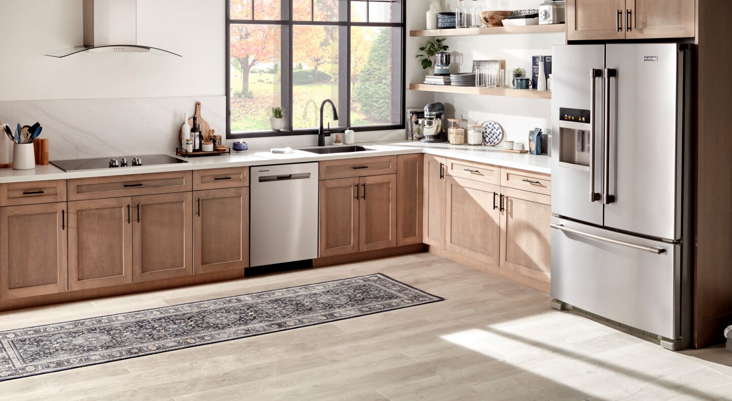 Stainless steel Maytag® French door refrigerator and dishwasher in cabinetry