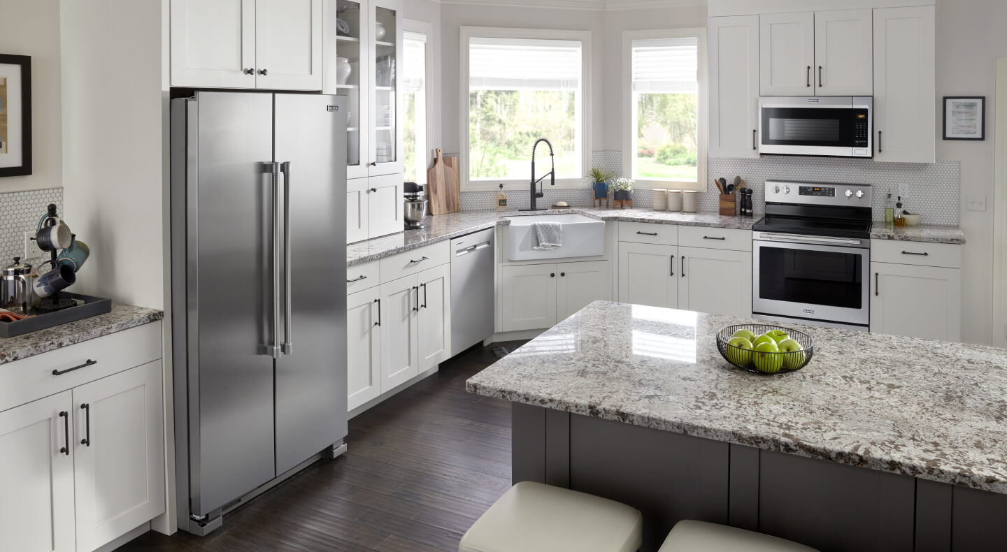 A bright kitchen with white cabinets and stainless appliances