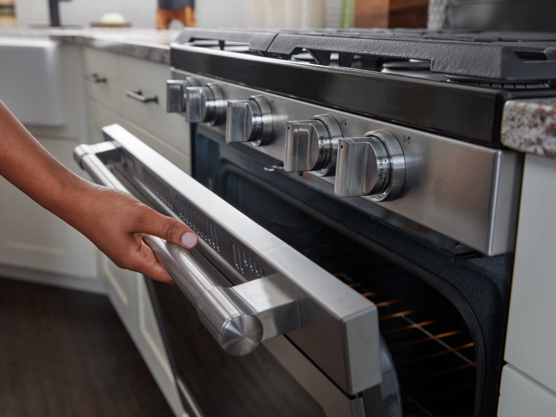 Person opening oven door Person opening oven door