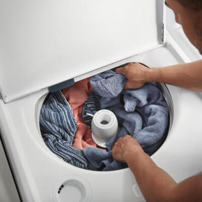 Person arranging laundry around an agitator