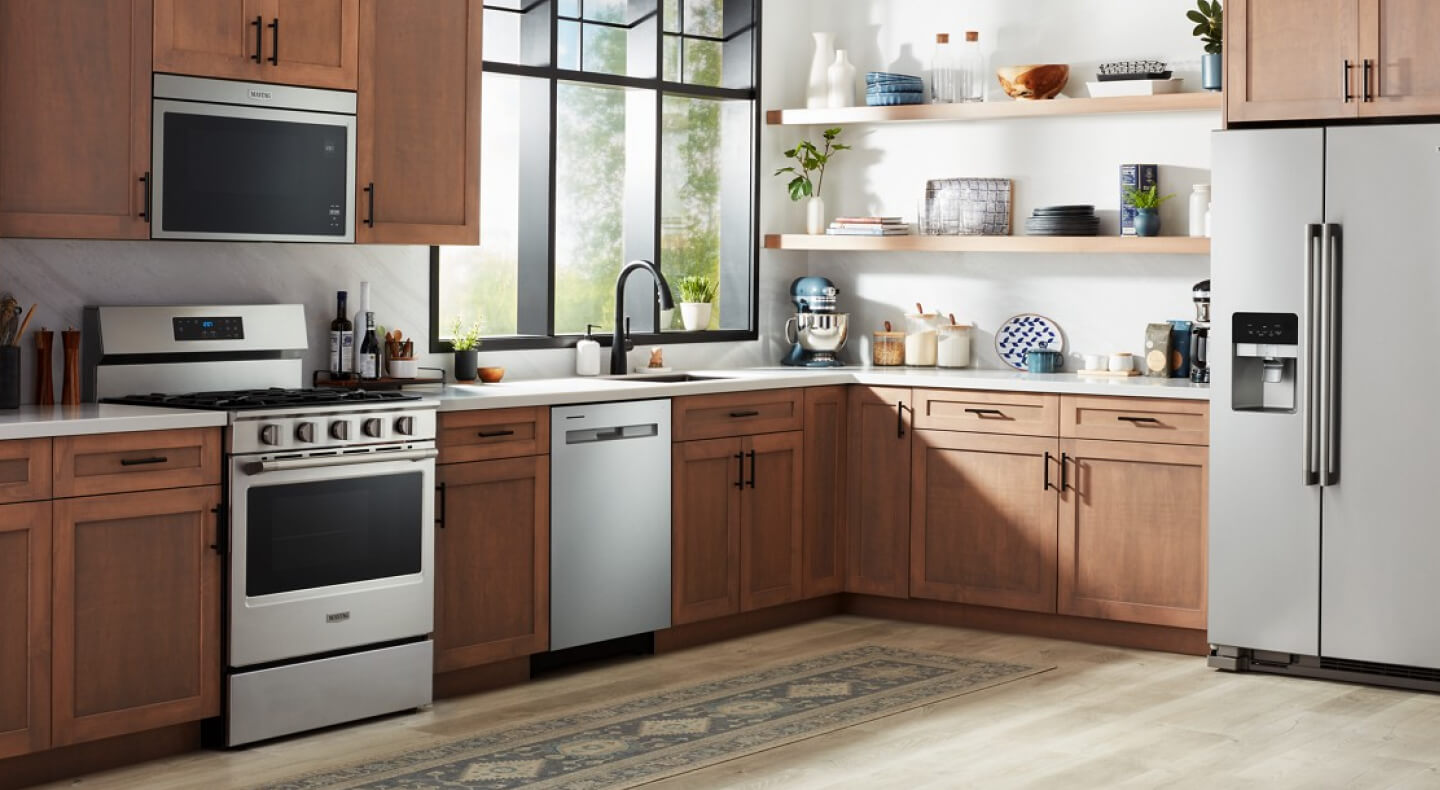 A Maytag® gas stove, over-the-range microwave, dishwasher and refrigerator in a modern kitchen