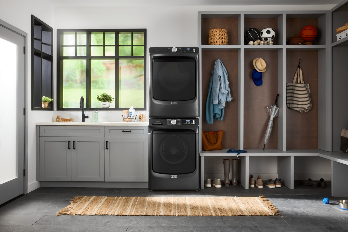 Stainless appliances in a kitchen with medium wood cabinets with black hardware