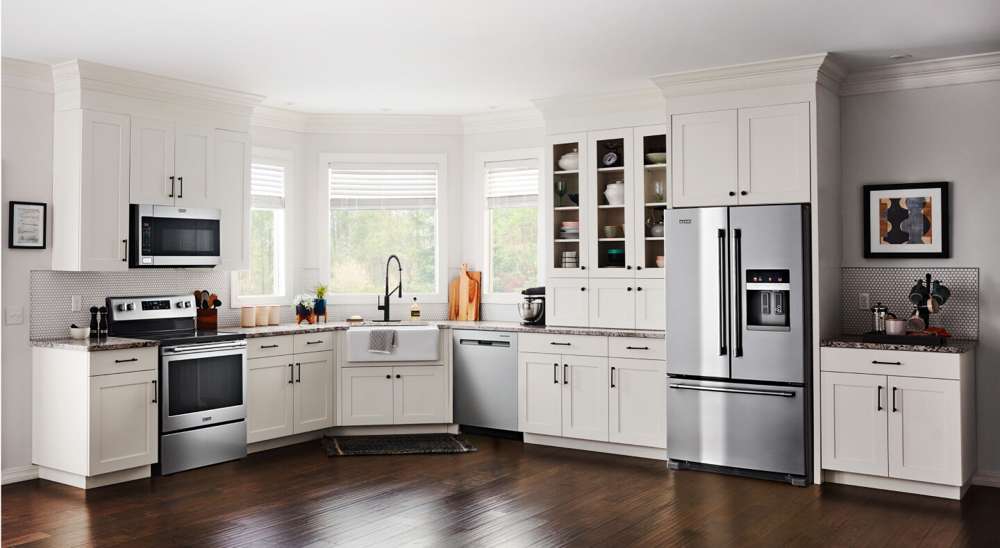 Modern kitchen with white cabinets and stainless steel Maytag® appliances Modern kitchen with white cabinets and stainless steel Maytag® appliances
