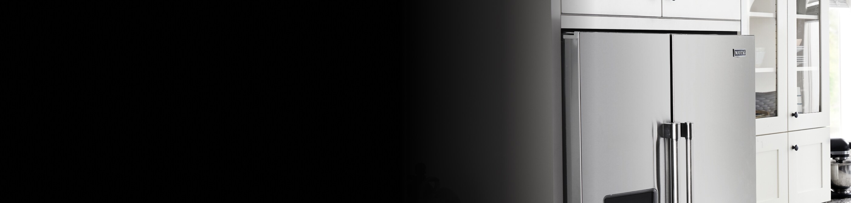 A stainless steel counter-depth refrigerator in a modern, white kitchen.