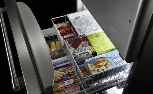 Open freezer drawer stocked with groceries