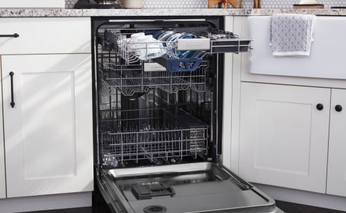 Open dishwasher set in white cabinetry