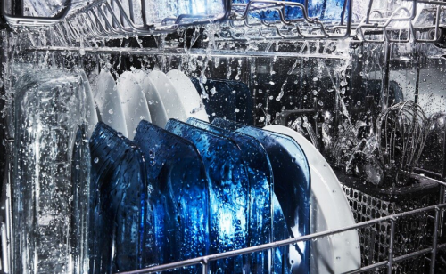 Water running over dishes in a dishwasher