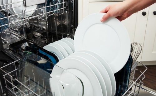 Dishwasher full of white plates