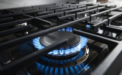 Close-up of blue flame on a gas cooktop burner