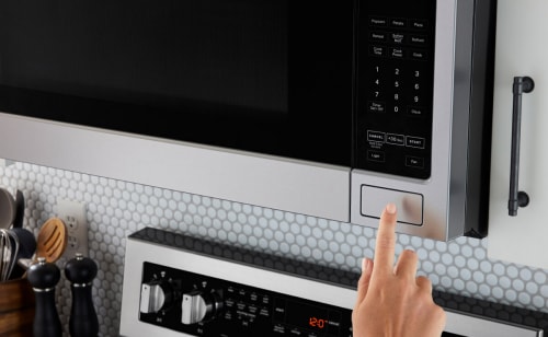 Hand opening an over-the-range microwave