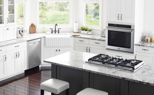 Interior overview of kitchen with gas range and wall oven.