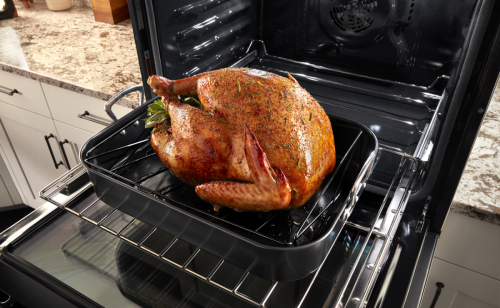 Roasted turkey on a roasting pan inside a Maytag® oven