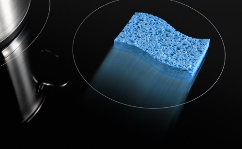 A sponge, moving across a glass cooktop