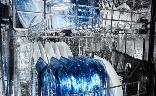 Maytag brand dishwasher filled with glassware.