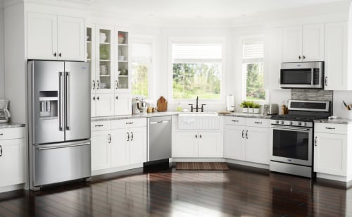 A modern white kitchen with Maytag® stainless steel appliances