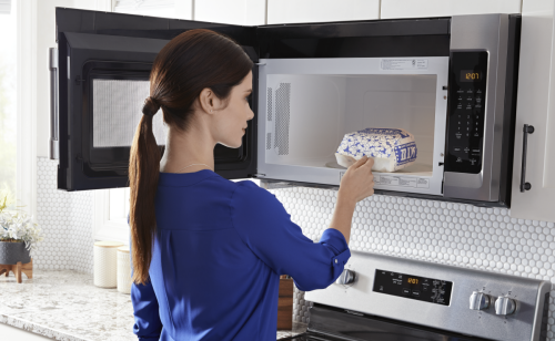 Person removing popcorn from the microwave