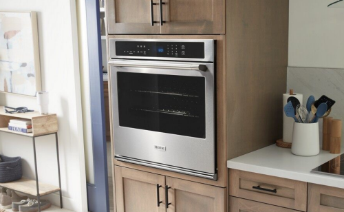 A Maytag® wall oven and a view of kitchen accessories on a countertop
