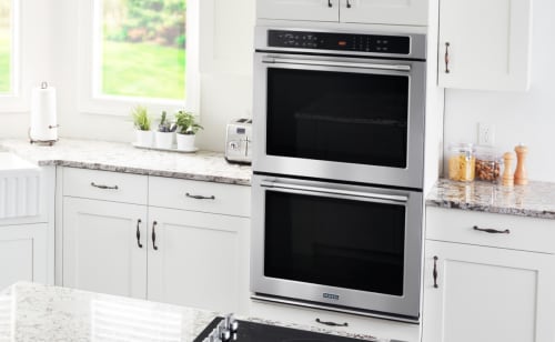 Stainless steel Maytag® electric range in brown cabinetry