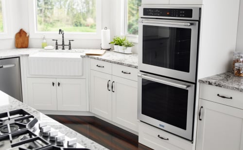 Double wall ovens in a white themed kitchen