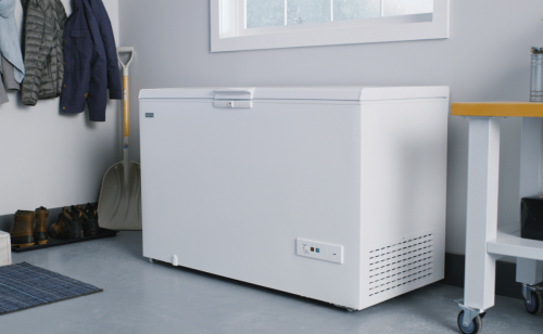 A white Maytag® chest freezer in a storage room