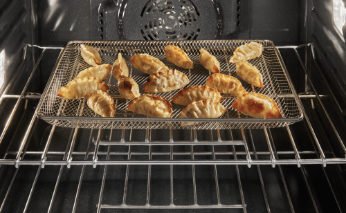 Several potstickers in a basket inside an oven