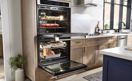 Double wall oven with open doors showing cooked dishes
