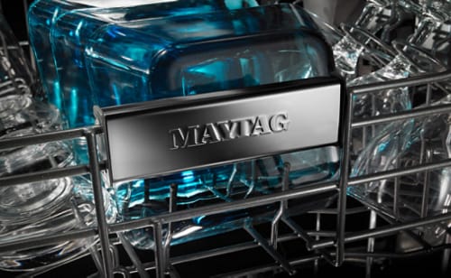 A closeup of the upper rack of the interior of a Maytag® dishwasher.