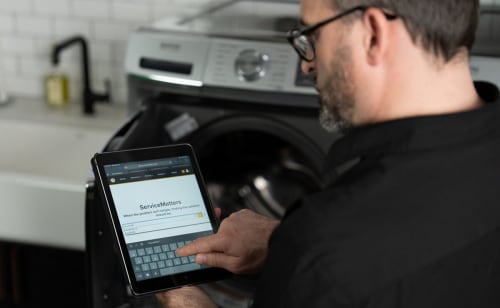 Person filling out a service form on a tablet