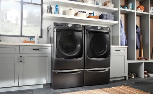Front load washer and dryer pair on pedestals from Maytag brand