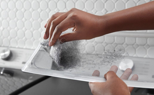 Person removing lint from a lint trap