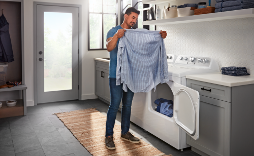 Man loading clothing into a front-load washer