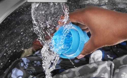 Hand rinsing detergent cup under running water