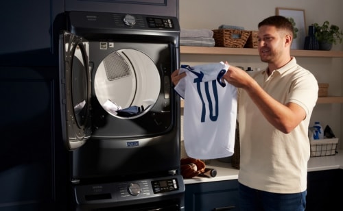 Person removing a jersey from a dryer