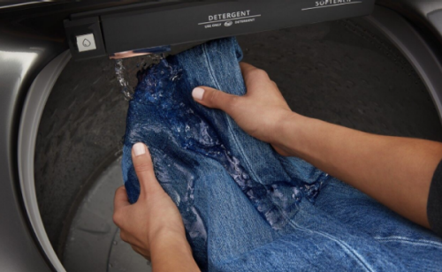 Jeans getting rinsed in the built-in water faucet.