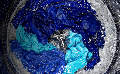Assorted blue clothes agitating in the washer