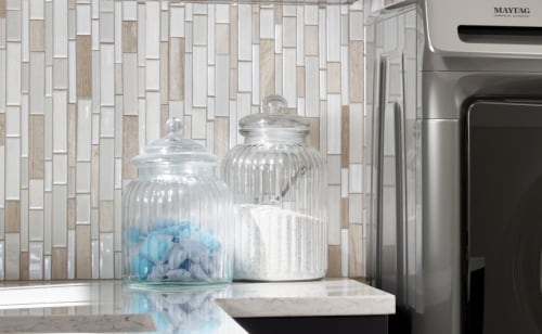 Glass containers filled with laundry pods and powdered detergent